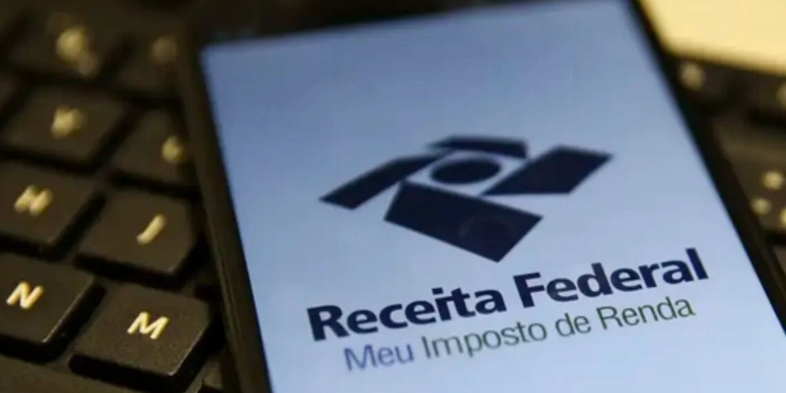Mãos de um colecionador segurando um álbum de figurinhas da Copa do Mundo FIFA 2026 aberto, com pacotes de figurinhas ao lado. O ambiente sugere uma lotérica da Caixa, com elementos discretos da marca ao fundo. Foco no detalhe das figurinhas e do álbum, t