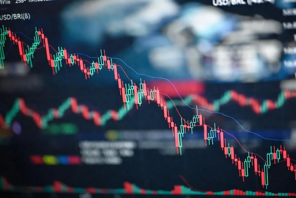 Gráfico de velas mostrando a cotação do USD/BRL em queda acentuada, com setas vermelhas indicando a desvalorização do dólar, sobre um fundo abstrato com elementos financeiros digitais.