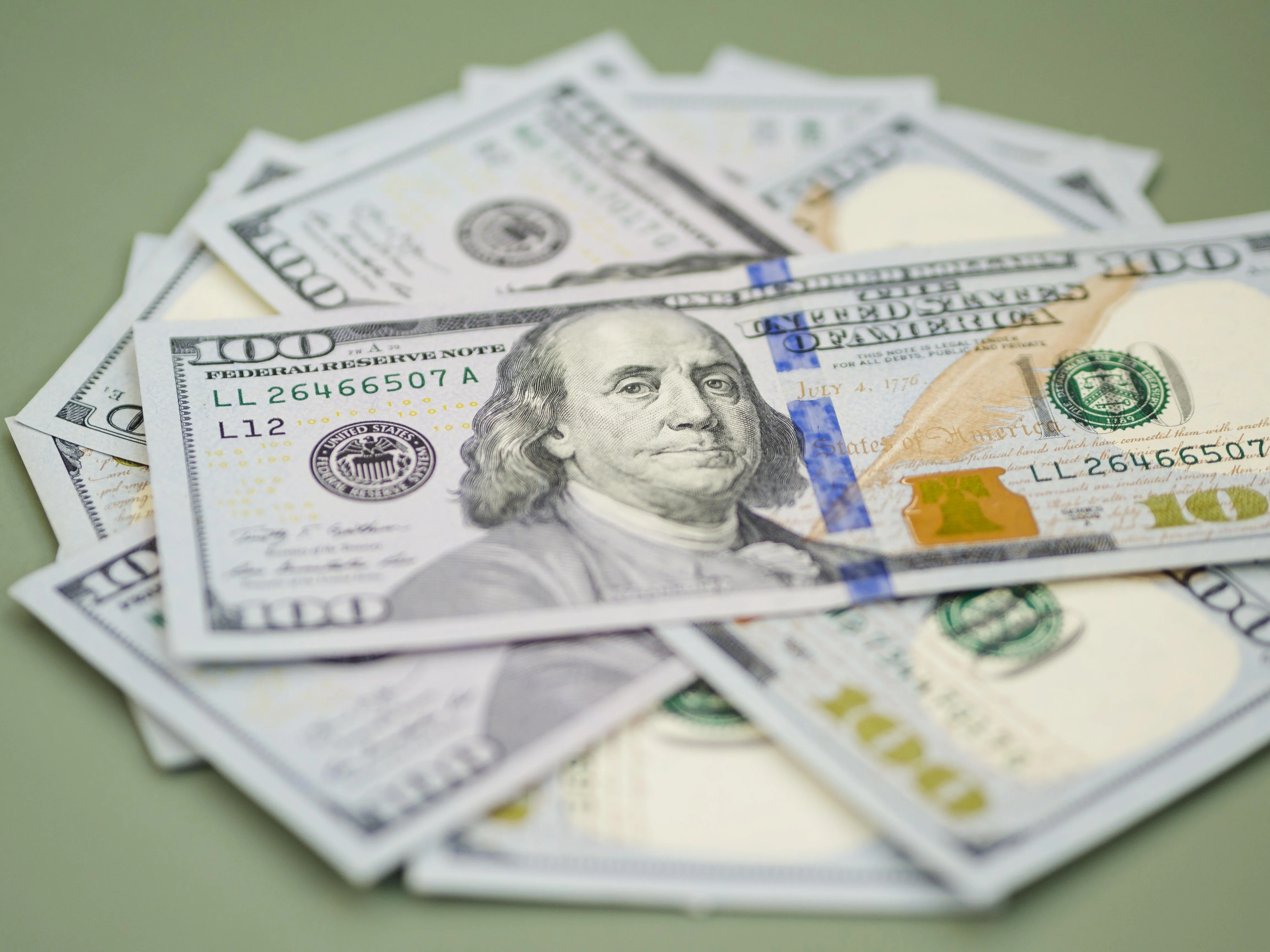 Uma mão segura um tablet exibindo um gráfico de barras financeiro em alta, enquanto no fundo, moedas de dólar e reais flutuam. Ao lado, um mapa mundi com foco no Oriente Médio e nos Estados Unidos simboliza a geopolítica. A cena é dinâmica, com cores que 