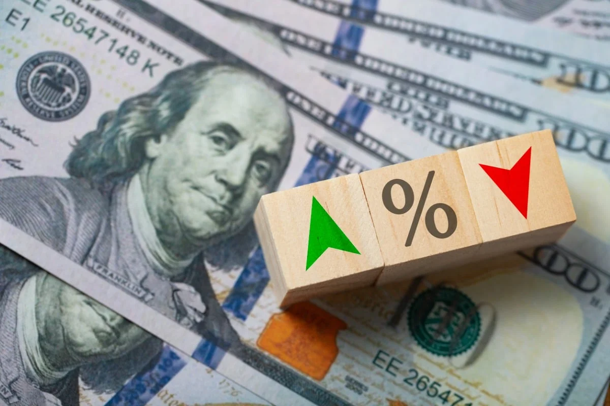 Uma plataforma de extração de petróleo em alto-mar sob um céu dramático de fim de tarde, com gráficos financeiros sobrepostos em tons de azul e dourado.