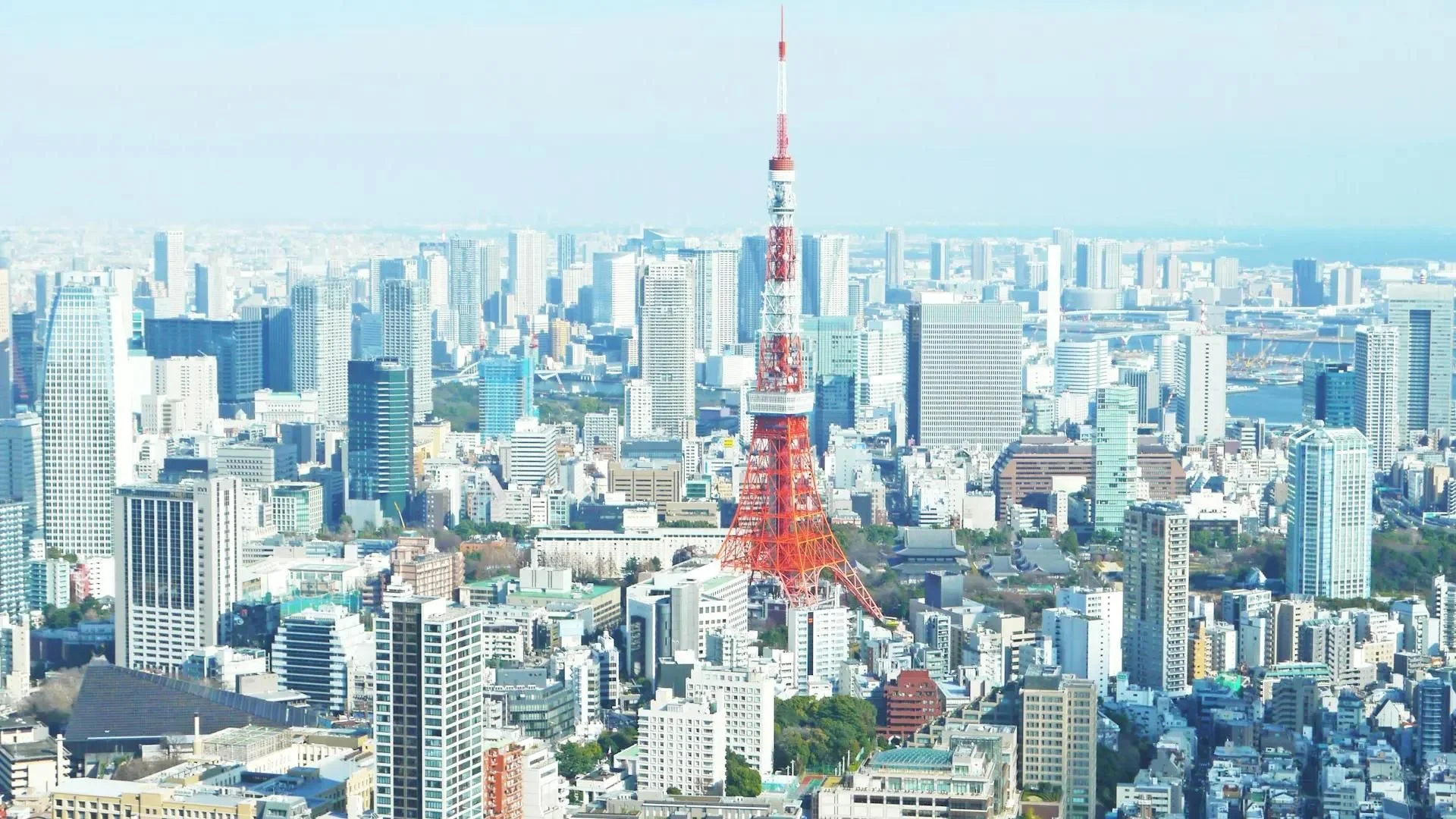 Uma representação visual de moedas digitais douradas sobrepostas a um mapa do Japão estilizado com gráficos de velas financeiras em tons de azul e dourado.