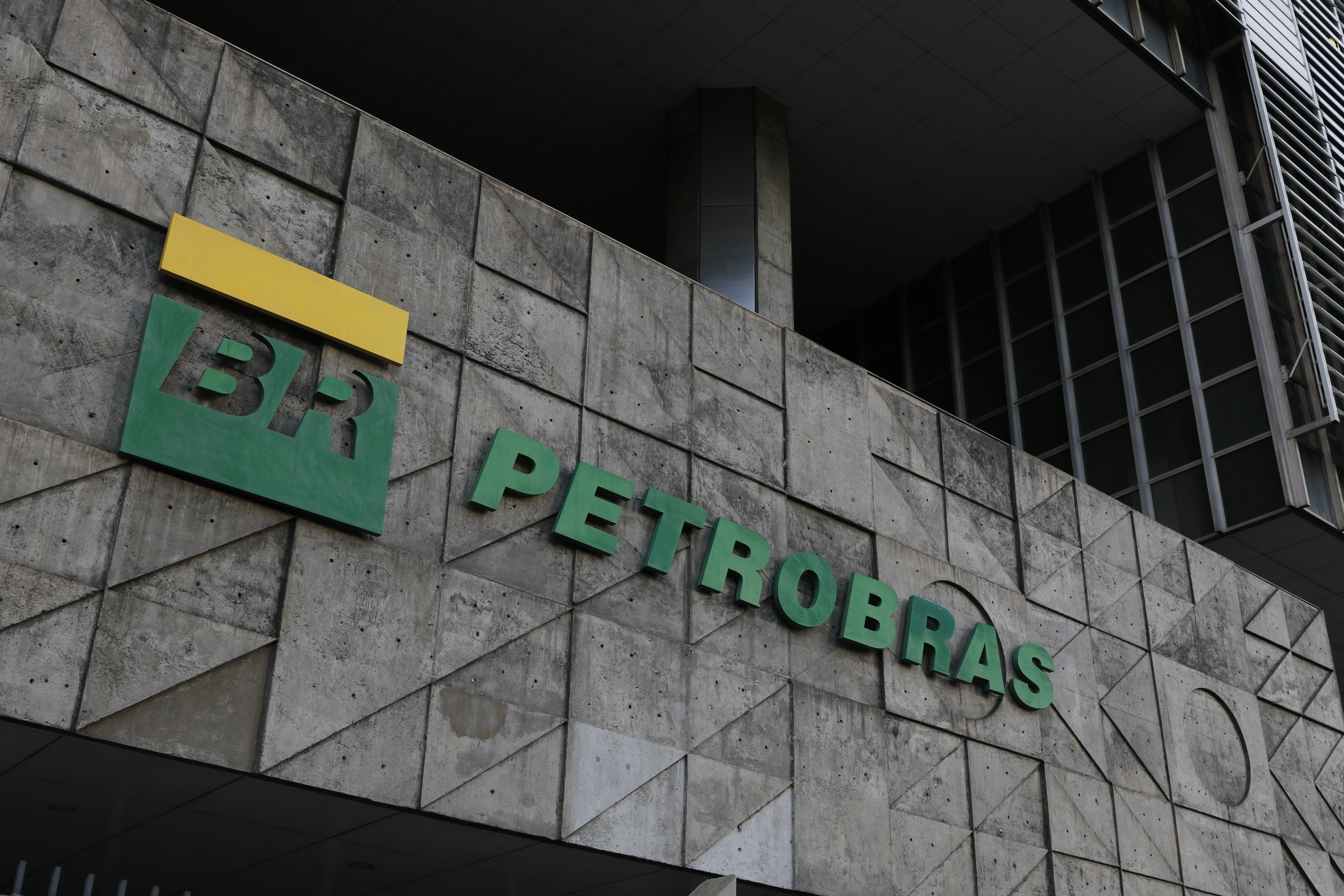 Um caminhão-tanque de diesel da Petrobras em uma rodovia movimentada ao pôr do sol, com a logo da empresa visível. O céu laranja reflete a tensão no mercado de combustíveis.